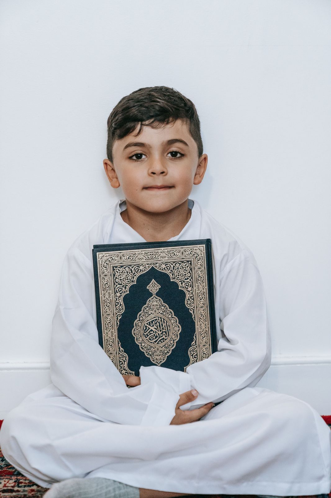 Young Muslim boy holding the Quran