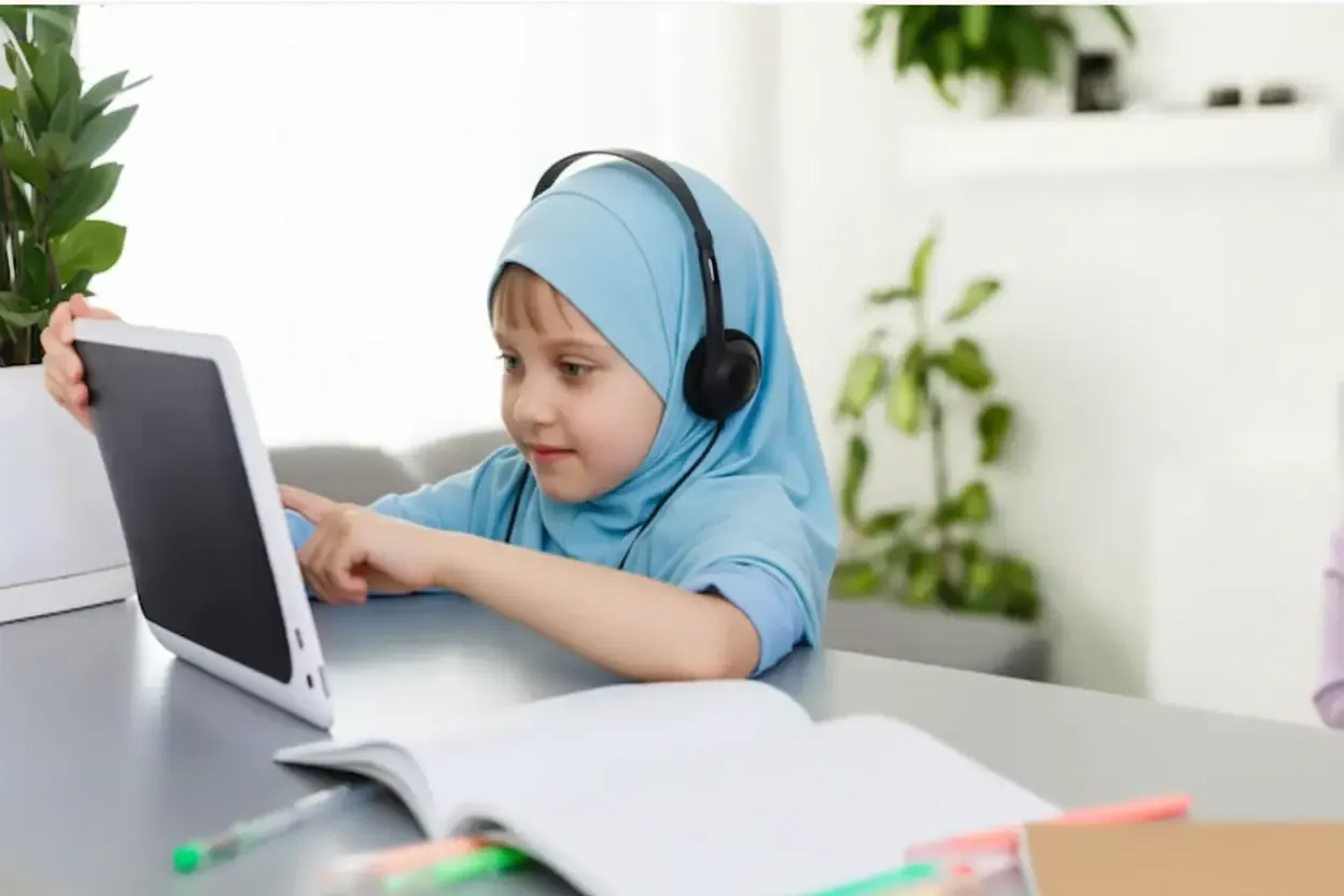 Muslim child taking online Quran classes on a laptop with a certified tutor