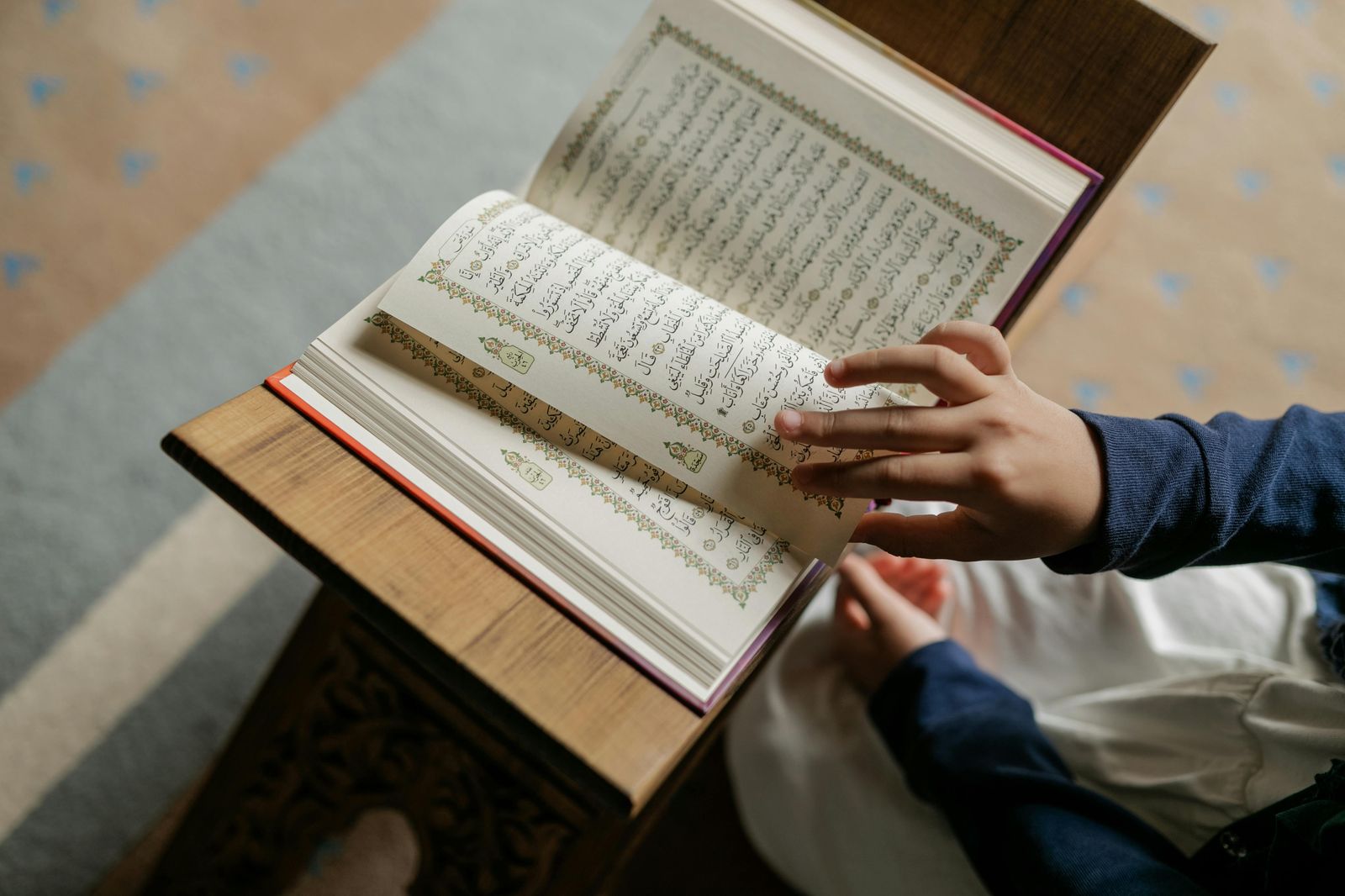 Childs hands turning the pages of the Quran